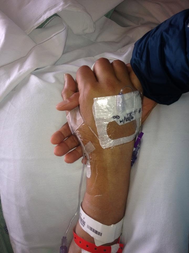 A daughter holding her mother's hand, IV line taped to the wrist
